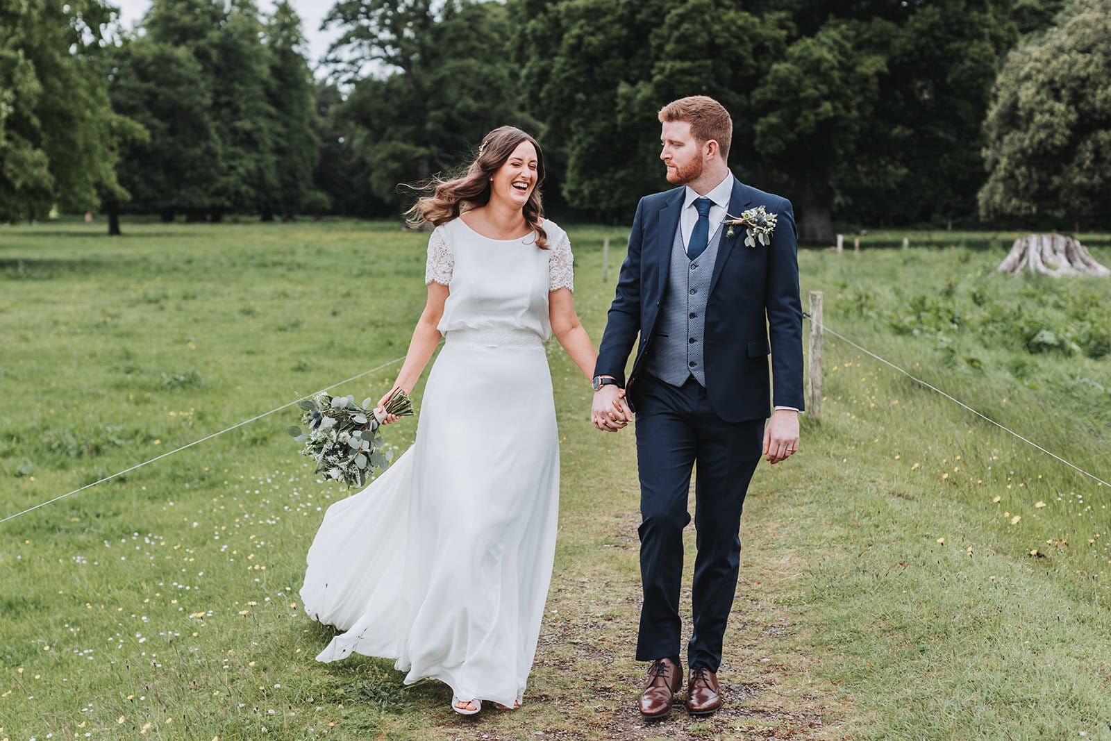 Bride and Groom walking in field